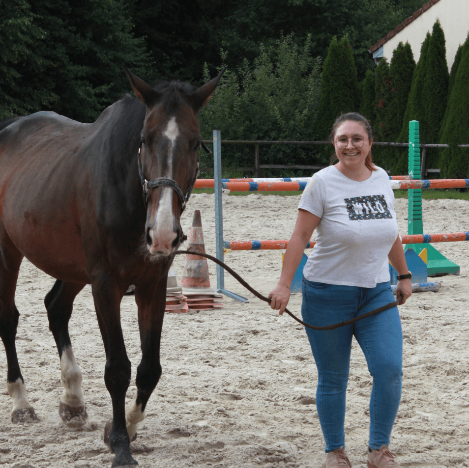 a woman is leading a horse around an obstacle course